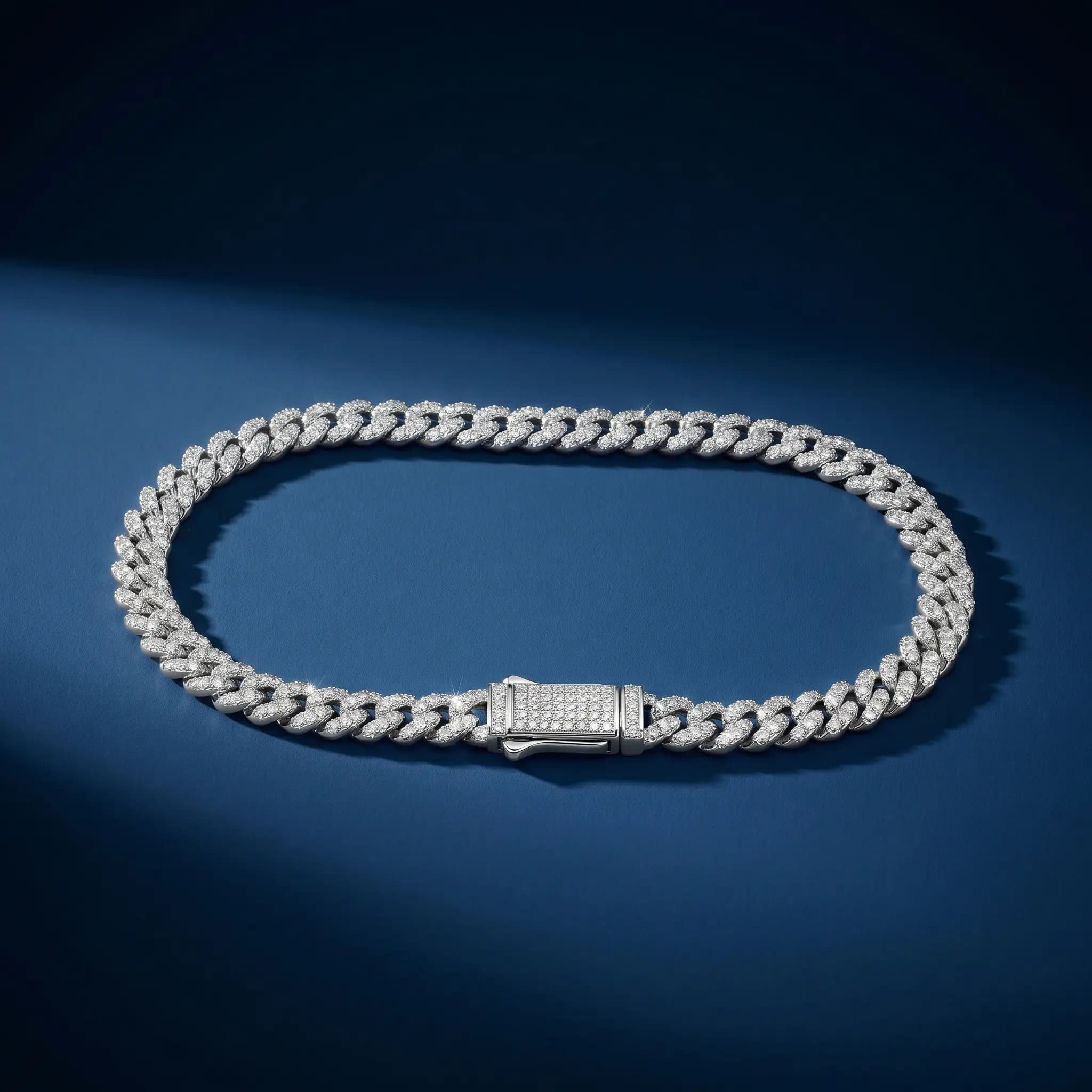 Silver Cuban link bracelet with pavé diamonds on blue backdrop — AI jewelry photography for online stores