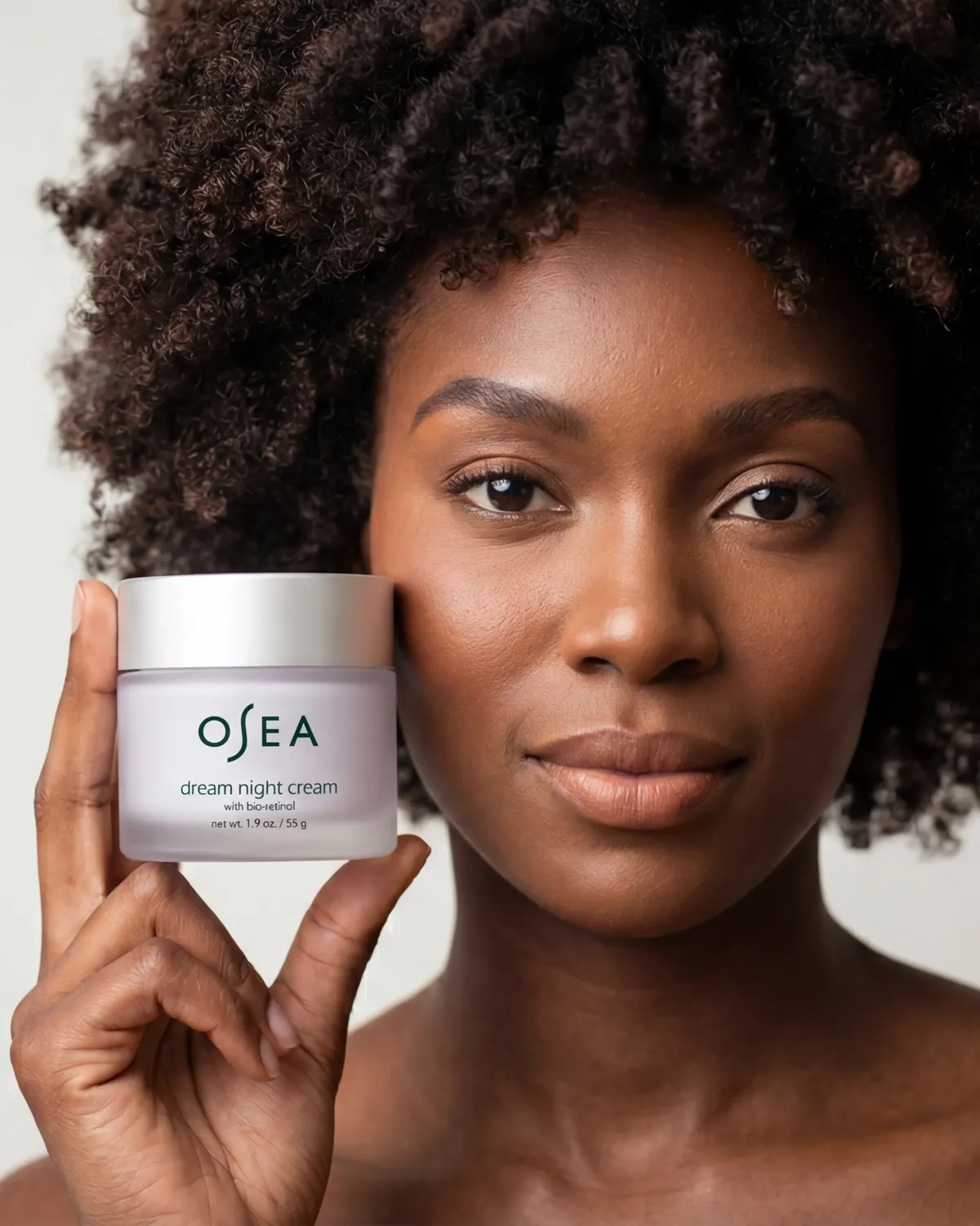 Woman holding skincare cream jar near face — AI skincare product photography for D2C beauty brands