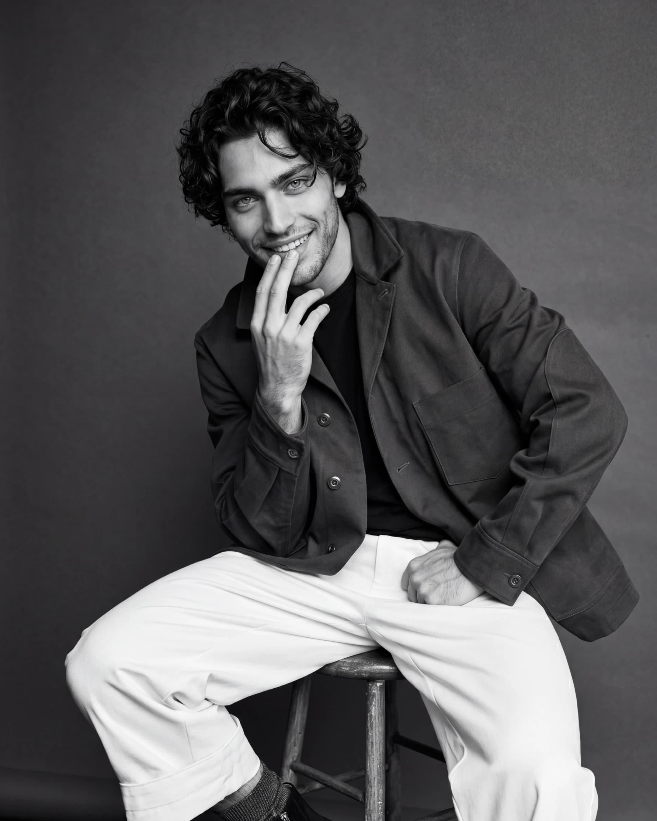 Black-and-white portrait of man on a stool — AI menswear editorial product photography for ecommerce